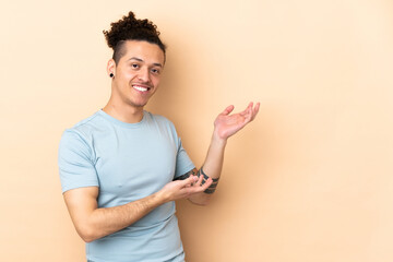 Caucasian man over isolated background extending hands to the side for inviting to come - obrazy, fototapety, plakaty