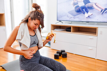 Woman holding belly fat worried while doing home workout