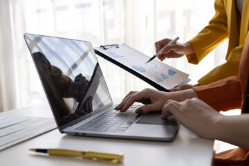 business women working on desk office with using a calculator to calculate the numbers tax, finance accountingresearch or financial strategy in company concept