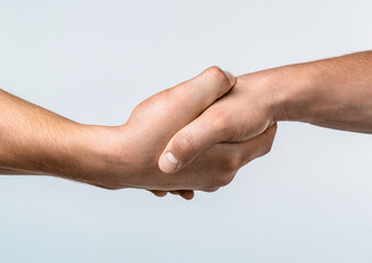Friendly handshake. Two hands, shaking hands. Two hands, helping arm of a friend, teamwork. Rescue, helping gesture or hands. Close up help hand. Helping hand concept, support