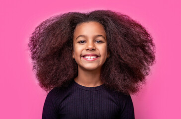 Smiling beautiful african girl with healthy white teeth. Smile little american girl. Girl smile and curly hair. Laughing cute afro girl portrait. 