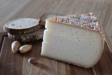Tomme de fromage mixte vache et chèvre sur plateau en bois