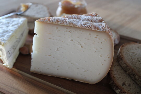 Tomme de fromage mixte vache et ch&egrave;vre sur plateau en bois