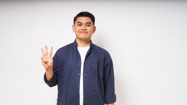 Young Asian man showing tiga fingers sign