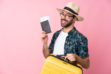 Young caucasian man over isolated background in vacation with suitcase and passport