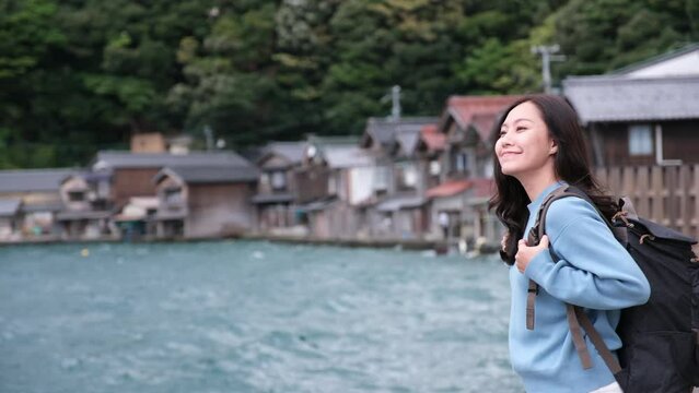 A female tourist standing by the ocean in Ine village, Japan