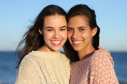 Two happy women smiling with perfect smiles at camera
