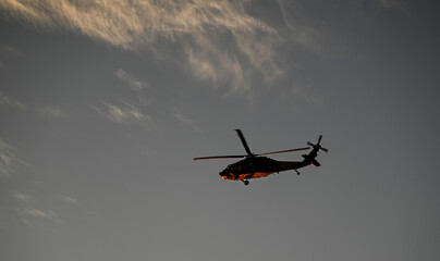 Fototapeta premium Isolated high resolution image of a distant Israeli air- force black hawk helicopter with a beautiful sunset background