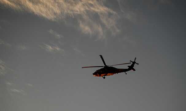 Isolated high resolution image of a distant Israeli air- force black hawk helicopter with a beautiful sunset background