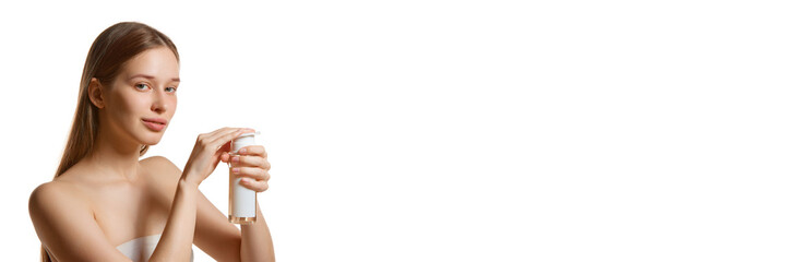 Banner. Young beautiful brunette woman applies tonic liquid with vitamins and minerals for facial...