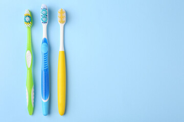 Many different toothbrushes on light blue background, flat lay. Space for text