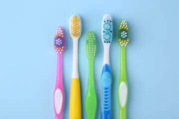 Many different toothbrushes on light blue background, flat lay