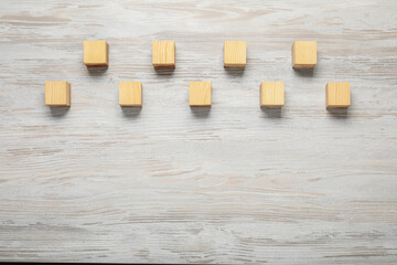 Blank cubes on white wooden table, flat lay. Space for text