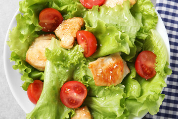Delicious salad with chicken and cherry tomato on table, top view