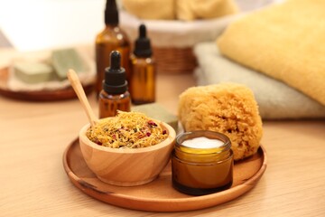 Dry flowers, loofah and jar with cream on wooden table. Spa time