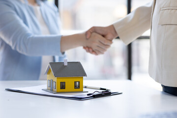 Handshake Real estate brokerage agent Deliver a sample of a model house to the customer, mortgage loan agreement Making lease and buy and sell house And contract home insurance mortgage loan concept	