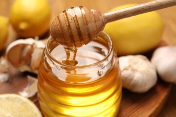 Pouring honey from dipper into jar on table, closeup - obrazy, fototapety, plakaty