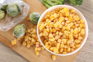 Frozen vegetables on wooden table, flat lay