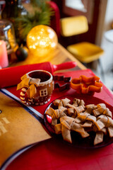 Homemade gingerbreads and festive cup on table at home. Winter holidays mood and decorations concept