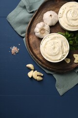 Tasty sauce with garlic and parsley on blue wooden table, flat lay. Space for text