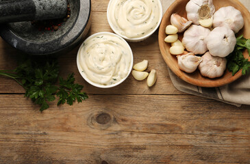 Tasty sauce with garlic and parsley on wooden table, flat lay. Space for text