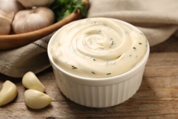 Tasty sauce with garlic on wooden table, closeup