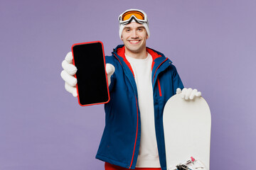 Happy man wear warm blue windbreaker jacket ski goggles mask hat hold snowboard use blank screen...