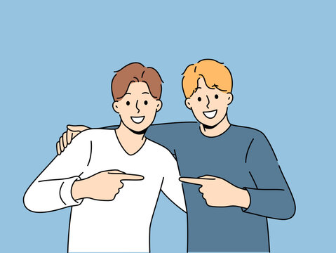 Two men friends hug and point finger towards buddy, rejoicing at long-awaited meeting. Boys brothers or friends smile looking at screen and experience positive emotions from opportunity to communicate