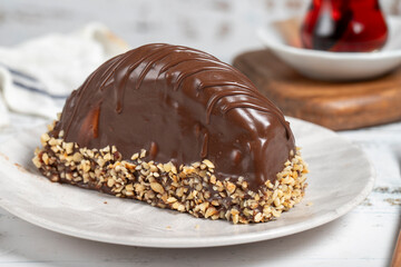Chocolate and banana cake. Malaga cake on wooden background. Large chocolate eclairs. Close up