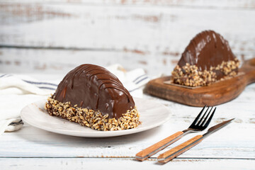 Chocolate and banana cake. Malaga cake on wooden background. Large chocolate eclairs