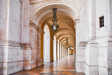 Passage architecture of Lisbon, Portugal. Corridor gallery with arches and columns. Praca Do Comercio. Arcades antique lanterns in Lisboa