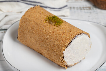 Creamy roll cake. Portion cake on wooden background. Close up