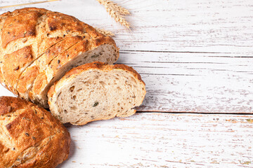 Sliced whole grain bread with seeds on wooden background.