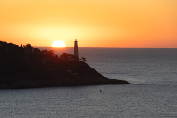 Coucher de soleil en bord de mer sur le phare de la presqu'île du Cap Ferrat depuis le Cap de Nice © Bernard