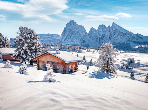 Tourist takes picture on smartphone of Alpe di Siusi village with Plattkofel peak on background. Cold morning view of Dolomite Alps. Snowy outdoor scene of Ityaly, Europe. Traveling concept background