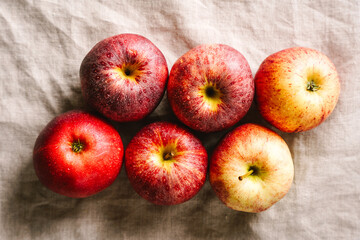 Rote Äpfel auf einem beigen Leinen Tischtuch. Draufsicht, Obst.