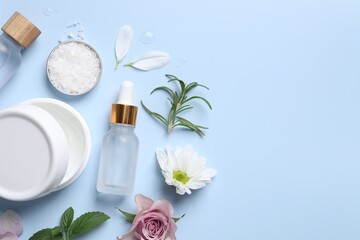 Flat lay composition with bottles of cosmetic serum on light blue background. Space for text