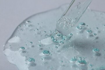 Pipette with cosmetic serum on white background, closeup. Space for text