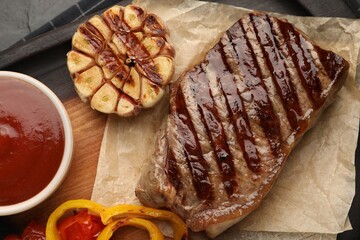 Delicious grilled beef steak with spices and tomato sauce on table, top view