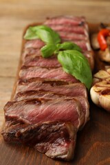 Delicious grilled beef steak with spices on wooden table, closeup