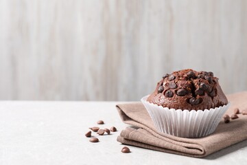 Tasty chocolate muffin on grey table, closeup. Space for text