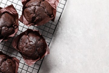 Tasty chocolate muffins on grey table, top view. Space for text