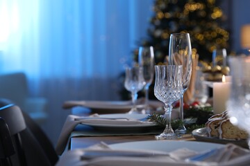 Christmas table setting with festive decor and dishware in room