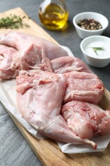 Fresh raw rabbit legs on black table, closeup