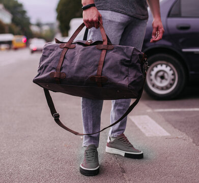 Man hold brown shoulder canvas bag in hand