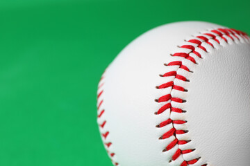 One baseball ball on green background, closeup. Space for text