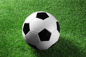 Fototapeta premium One soccer ball on green grass. Sports equipment