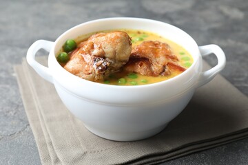 Tasty cooked rabbit meat with sauce and peas on grey table, closeup