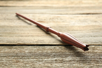 One old magic wand on wooden table, closeup