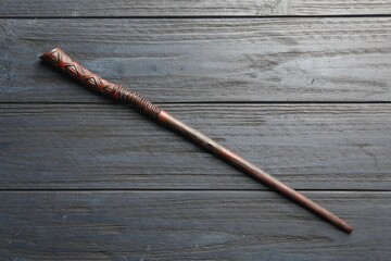 One old magic wand on grey wooden table, top view
